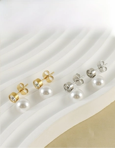 Dettaglio di orecchini a perno con perle placcati in oro 18K e argento con cristalli