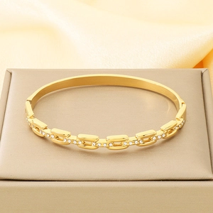 Detailed view of gold plated chain texture bracelet with inlaid small white zircons