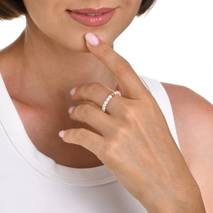 Minimalist stainless steel pearl beaded ring with a central gold bead on model's hand