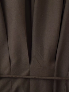 Close-up of pleated dark brown fabric texture with matching thin waist belt detail