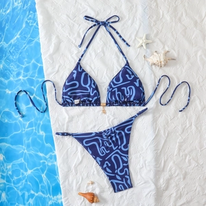 Blue wave print halter bikini set with gold hardware and side-tie bottoms laid flat