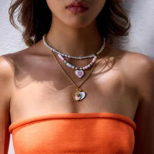 Gros plan de pendentifs en cœur sur une chaîne dorée et un collier de perles colorées