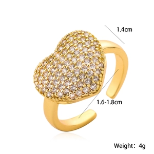 Detailed macro view of gold heart ring featuring white zircon stones and open adjustable band