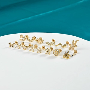 Gold plated stainless steel ear piercing set featuring moon star and leaf shapes with crystals