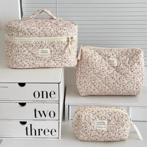Three-piece beige floral quilted makeup bag set with zipper and fabric label