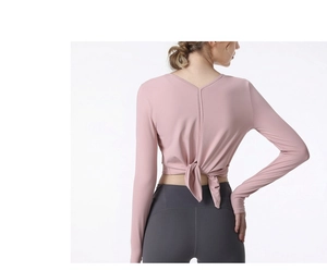 Detail view of pink long-sleeved athletic top featuring a unique cross-strap open back design