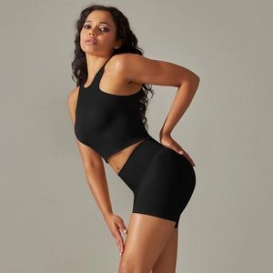 Detail of black seamless ribbed knit fabric on a high-waisted yoga bra and shorts set