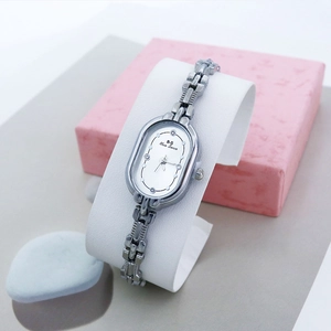 Détail de la petite montre ovale pour femme avec bracelet métallique argenté et diamants