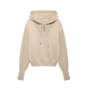 Detail of beige knit hoodie featuring V-neck zipper, drawstring hood and ribbed cuffs