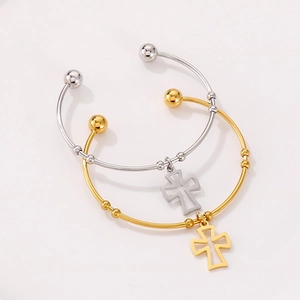 Detail of gold and silver stainless steel open bangles with hollow cross charms