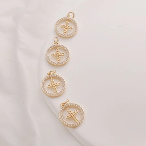 Detailed view of four 14K gold-plated cross pendants with sparkling zircon stone borders