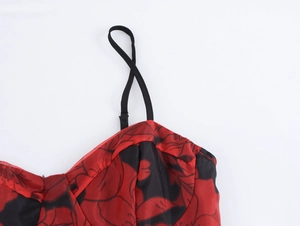 Détail des bretelles réglables noires et du tissu organza rouge à fleurs
