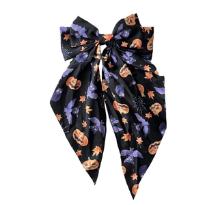 Halloween bow hair clip with pumpkin bat and spider web patterns on long black ribbon
