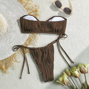 Close-up of brown ribbed fabric bikini with side ties, straw hat and sunglasses