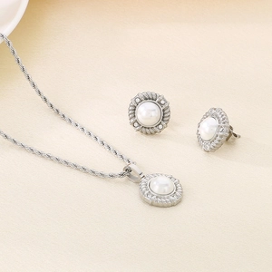Detailed view of silver necklace and stud earrings set with white pearls and rope texture