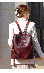Zaino in pelle PU bordeaux con trama geometrica indossato da una modella all'aperto