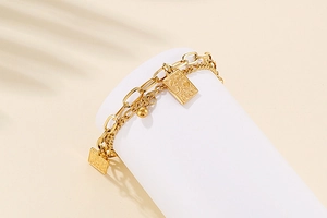Double-layer gold chain bracelet with square poker card pendant and gold bead details