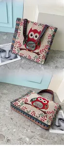 Detailed view of owl embroidery and ethnic striped patterns on the canvas tote bag