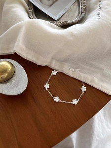 Detailed view of an S925 sterling silver flower bracelet on a dark wooden surface