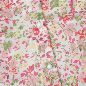 Detailed view of floral print fabric with elegant pearl buttons on the front placket