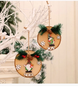 Detailed view of wood slice ornament with pine needles and JOY NOEL lettering