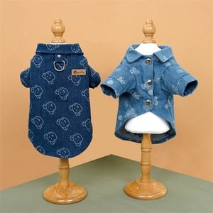 Close-up of denim pet shirt with cartoon bear print and metal buttons on display