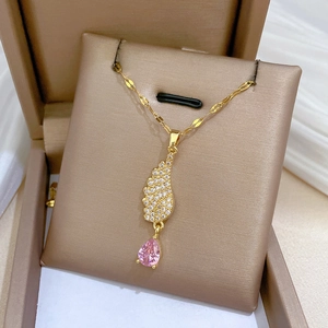 Close-up of angel wing necklace with pink teardrop crystal in a jewelry box