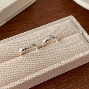 Detail view of two minimalist irregular 925 silver rings in a soft beige jewelry box