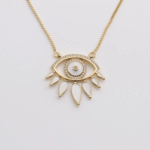 Detail of gold evil eye pendant necklace with white enamel drops and box chain