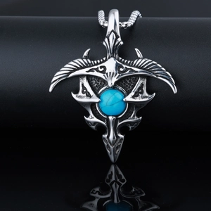 Close-up of eagle wing pendant with vintage silver finish and turquoise gemstone inlay