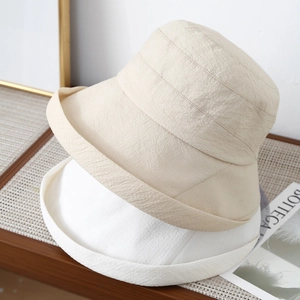 Detailed texture of beige and white sun hats in foldable pleated fabric, Japanese style