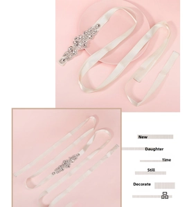 Detail of bridal sash with rhinestones and ivory satin ribbon on pink background