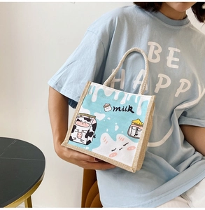 Detail of small canvas tote bag with cartoon cow print and woven rope handles