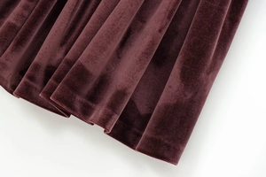 Close-up of premium burgundy velvet fabric showing soft texture and elegant pleats