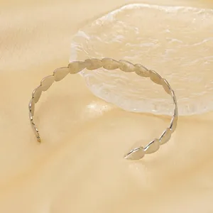 Minimalist silver stainless steel open bangle with continuous heart pattern on silk fabric