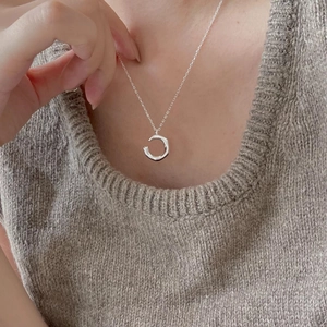 Macro view of 925 sterling silver irregular ring pendant worn on a knit sweater