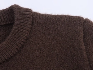 Close-up of the ribbed crew neck and plush knit texture of the dark brown cardigan