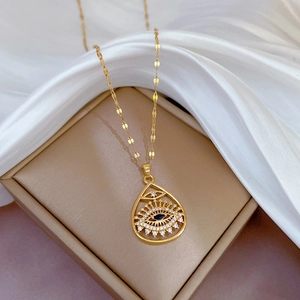 Titanium steel gold necklace with teardrop Eye of Horus pendant on white silk fabric