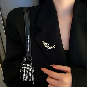 Broche élégante en forme d'épi de blé doré avec zircons sur une veste de costume noire