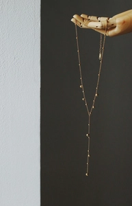 Detailed close-up of 18K gold plated Y-shaped tassel necklace featuring K18 stamp