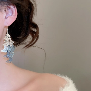 Gros plan de boucles d'oreilles papillon élégantes avec dégradé bleu sur un mannequin