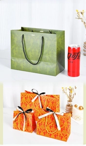Classic Damascus pattern gift bags in forest green and orange with ribbon handles