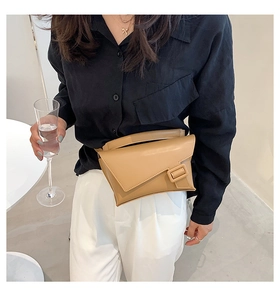 Detail of khaki leather waist bag with unique geometric flap and square buckle on model