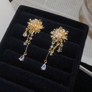 Detailed macro view of gold plated fireworks earrings with sparkling zircon tassels