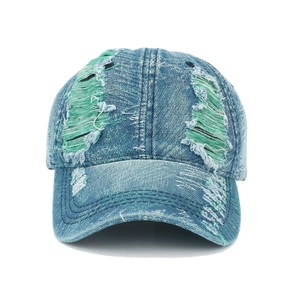 Detail of blue distressed denim cap with vintage ripped texture and green fabric lining