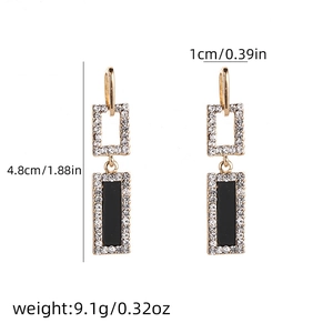 Detail view of gold earrings featuring black square stones and dimensions 4.8cm x 1cm
