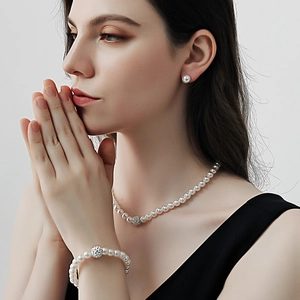 Dettaglio del set di gioielli da sposa in perle con collana, bracciale e orecchini indossati
