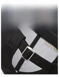 Detail of adjustable metal buckle and breathable texture on black camouflage baseball cap