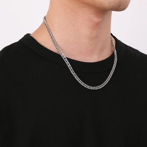 Close-up of a silver titanium steel curb chain necklace on a male model neck