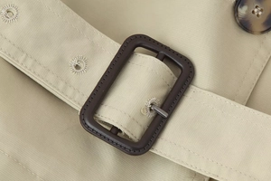 Detailed close-up of khaki twill jacket waist belt buckle with dark brown matte finish